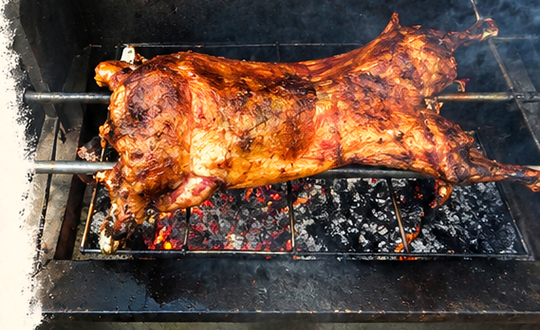 Whole pig roasting over hot coals on a grill